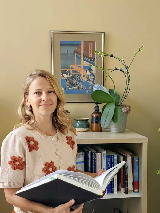 Dr. Skye Van Munster holding an open book in her clinic